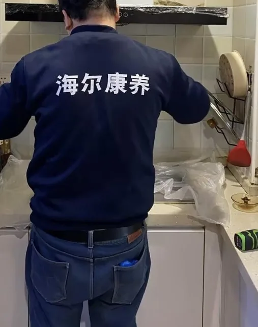 海尔康养清洗技师上门作业,灶台与烟机已做好保护